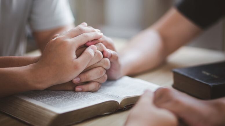 people comforting someone with a bible